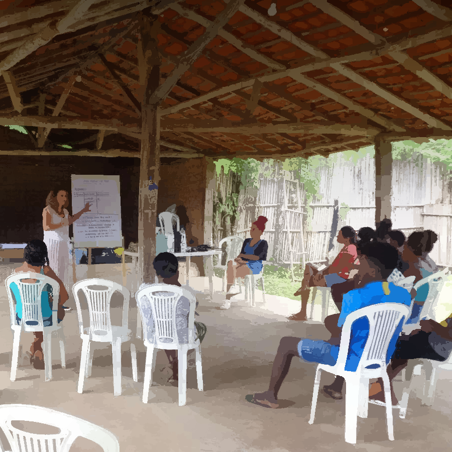 Podemos ver um grupo de pessoas reunidas em um espaço comunitário, para uma oficina.