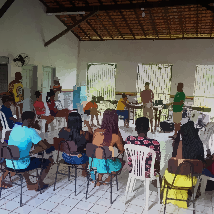 Podemos ver uma sala de aula com a comunidade discutndo o que aprenderam durante as oficinas de redes comunitárias.